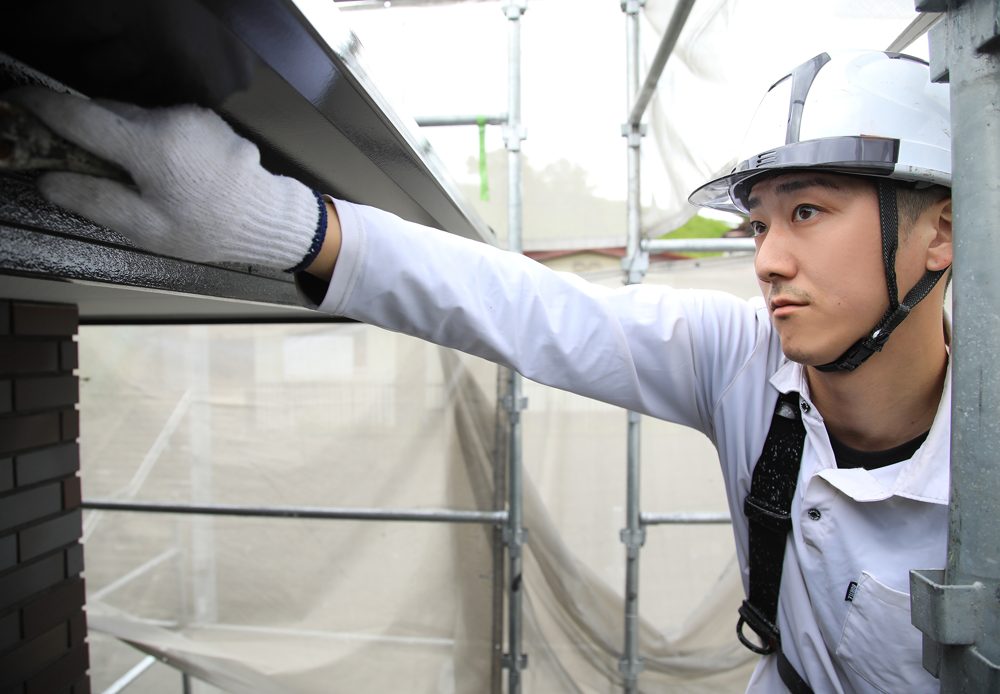 軒天を塗る当社の職人。下から見上げないと状態が分からない場所です