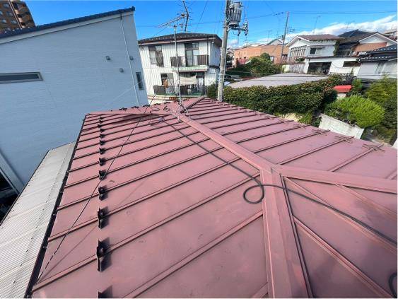 色あせと雨だれの黒い筋が残った外壁